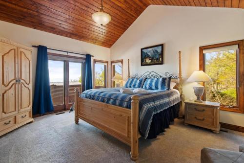 a bedroom with a bed with blue sheets and a wooden ceiling at Sunset Beech in Beech Mountain
