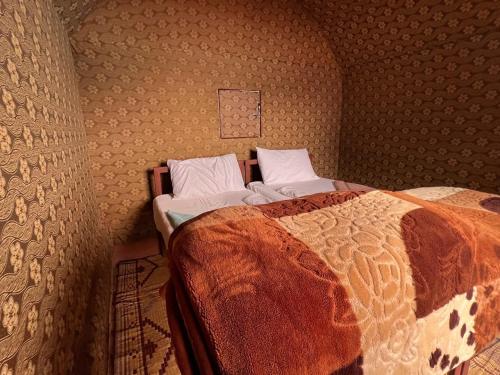 a bedroom with a bed with a comforter on it at Wadi Rum Desert Camp in Wadi Rum