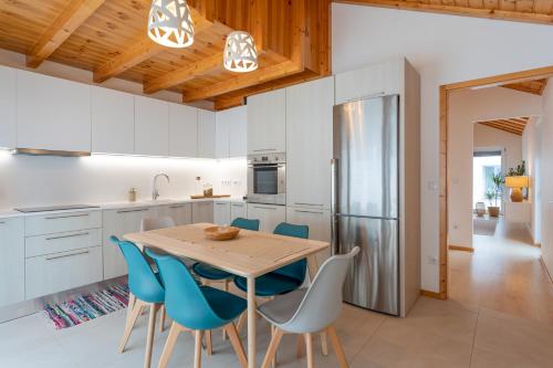 a kitchen with a wooden table and blue chairs at Apartamento Férias (Apartamento Sul) in Gafanha da Encarnação