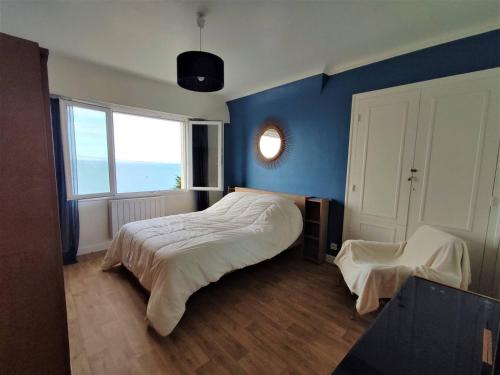 une chambre avec un lit et un mur bleu dans l'établissement Maison avec jardin clos à 800m de la plage à Trébeurden - FR-1-368-335, à Trébeurden