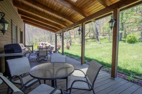 a porch with a table and chairs on it at The Retreat at Mountain Meadows in Banner Elk