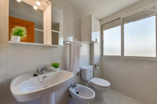 ein weißes Bad mit einem Waschbecken und einem WC in der Unterkunft Villas Guzman - Apartamento Apolo XI in Calpe