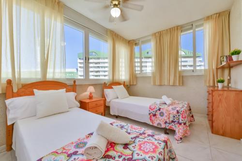 two beds in a room with windows at Villas Guzman - Apartamento Apolo XI in Calpe