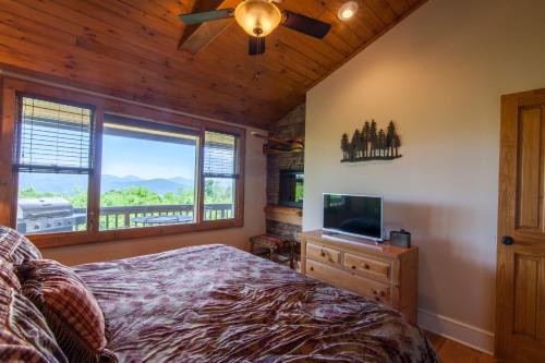 a bedroom with a bed and a flat screen tv at Top Of The Rock in Blowing Rock