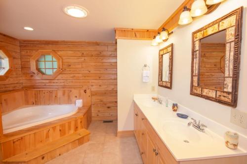 a wooden bathroom with a tub and a sink at Waters Edge Retreat in Wagoner