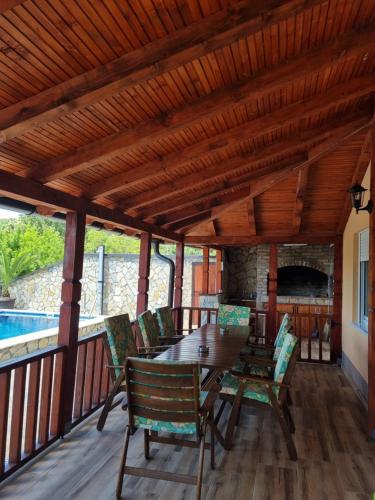 a dining room with a table and chairs on a deck at Pogled Vrdnik in Vrdnik