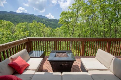 a patio with a couch and a fire pit on a deck at Villa Costalotta in Sugar Mountain