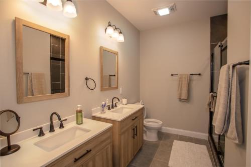 ein Badezimmer mit einem Waschbecken, einem WC und einem Spiegel in der Unterkunft Vistas at Trout Lake in Blowing Rock