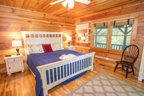 - une chambre avec un lit dans une cabane en rondins dans l'établissement Willow Valley View, à Vilas