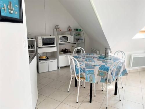 une cuisine avec une table et des chaises dans une pièce dans l'établissement Appartement Mansardé avec Garage au Centre de Perros-Guirec - FR-1-368-340, à Perros-Guirec