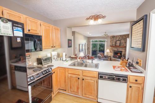 a kitchen with wooden cabinets and a sink at Yonahlossee Getaway in Boone