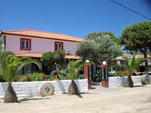 a house with palm trees in front of it at Studios Resbithas in Gythio