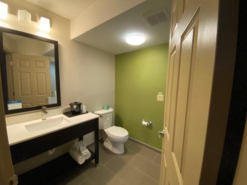 a bathroom with a toilet and a sink and a mirror at Sleep Inn & Suites Niantic North in Niantic