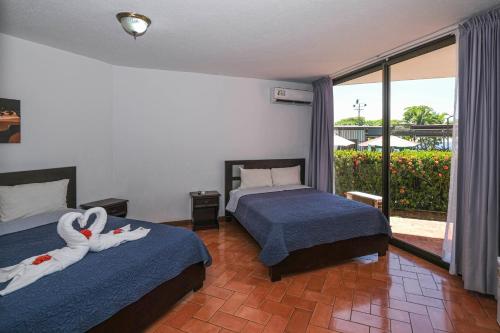 a bedroom with two beds with swans on them at Hotel Terraza del Pacifico in Jacó