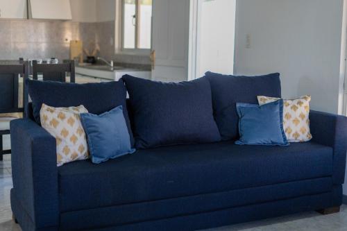 un sofá azul con almohadas en la sala de estar en Amplio, Verde y Privado. en Mendoza