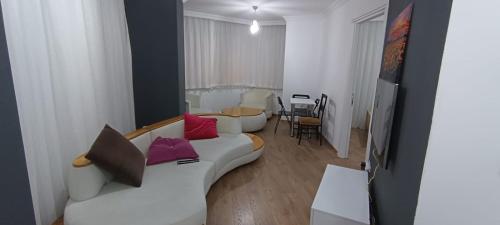 ein Wohnzimmer mit einer weißen Couch mit bunten Kissen in der Unterkunft Beşiktaş Merkez. in Istanbul