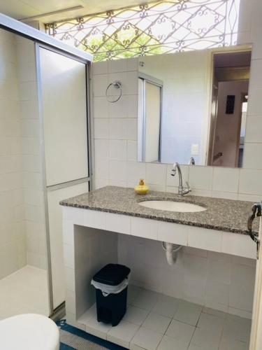 a bathroom with a sink and a mirror at Casa Tunis - poucos passos do mar in Paulista