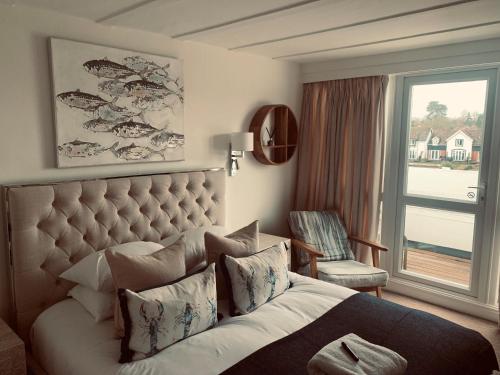 a bedroom with a large bed and a window at Hotel Wroxham in Wroxham