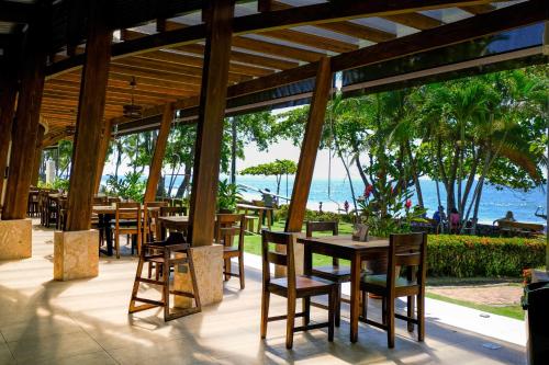 un restaurante con mesas y sillas y vistas al océano en Hotel Terraza del Pacifico, en Jacó