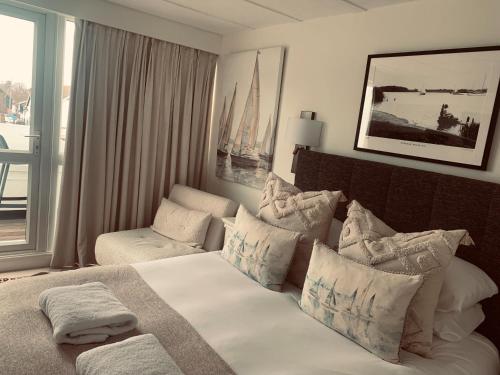 a hotel room with a bed and a couch and a window at Hotel Wroxham in Wroxham