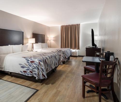 una camera d'albergo con letto e scrivania di Red Roof Inn & Suites Jacksonville, NC a Jacksonville
