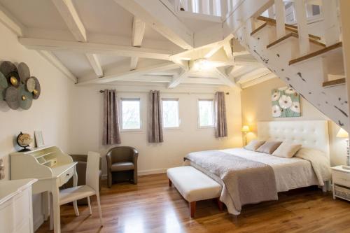 une chambre avec un lit, un bureau et une table dans l'établissement Les Jardins de Virginie, à Archignac