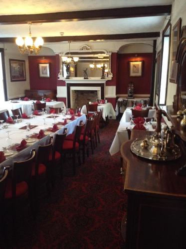 a dining room with tables and chairs and a fireplace at The Crown Hotel in Mundford