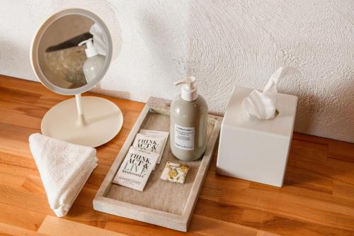 a table with a mirror and a bottle of moisturizing soap and a lamp at Blerina's Agritourism Concept in Laknas