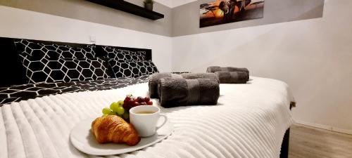 a plate of food on a bed with a cup of coffee at New Modern SelfCheckin PublicFreeParking HighSpeed Wifi KingSizeBed in Baden-Baden