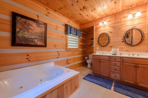 Cabaña de madera con baño con bañera y 2 lavabos en About Time en Vilas