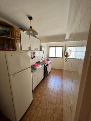 a kitchen with a white refrigerator and a tile floor at Naomi in Mar del Plata