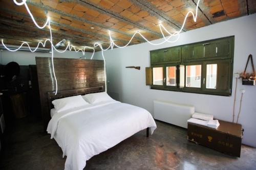 a bedroom with a white bed with lights hanging from the ceiling at Kazerma e Cerenit in Surrel