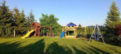 un parco giochi in un cortile erboso con una casa di Villa Corvina a Győrújbarát