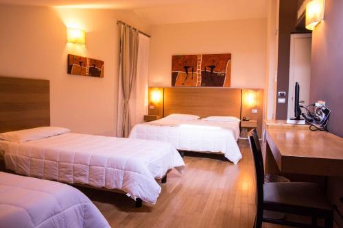a hotel room with three beds and a desk at Country House Corte Del Sole in Campolungo