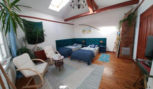 uma sala de estar com uma cama e cadeiras e uma televisão em Apartament ze słoneczną werandą -250 m do plaży em Sopot