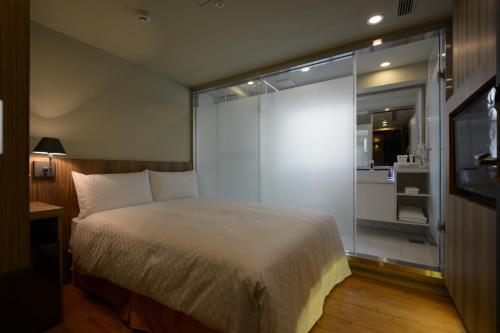 a bedroom with a bed and a sliding glass door at Smile Inn - Taipei Main Station in Taipei