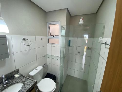 uma casa de banho com um chuveiro, um WC e um lavatório. em Condomínio Villamares em Luís Correia