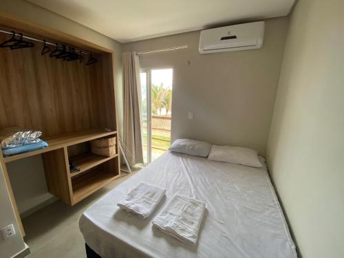 a bedroom with a bed with two towels on it at Condomínio Villamares in Luis Correia