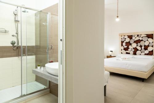 a bathroom with a shower and a sink and a bed at Amaltea in San Severino