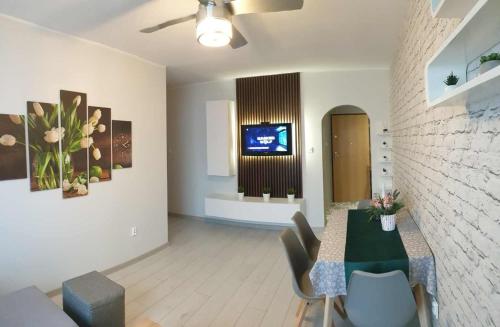 a living room with a table and chairs and a tv at APARTAMENT 2+2 in Konin