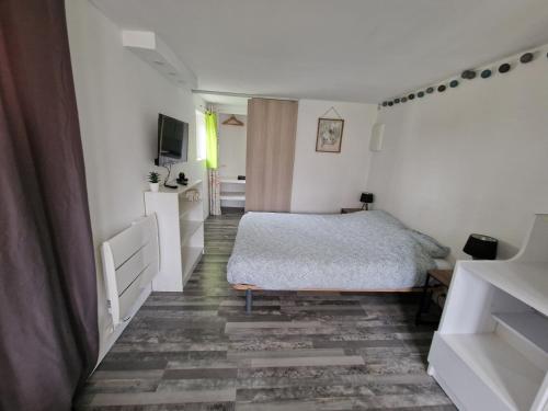 - une chambre blanche avec un lit dans l'établissement Studio Marmotte quartier marais, terrasse en rez de jardin, à Bourges