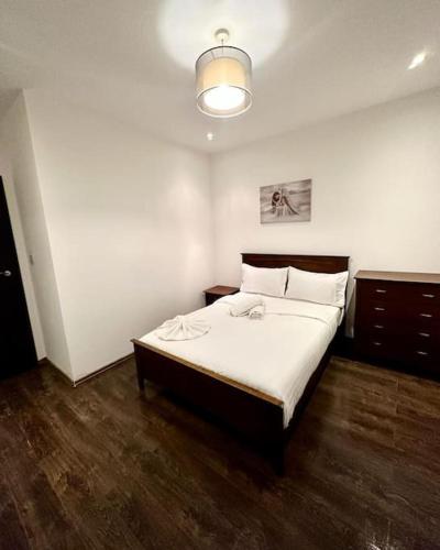 1 dormitorio con 1 cama grande con sábanas blancas en Alarabi Apartments-Peckham en Londres