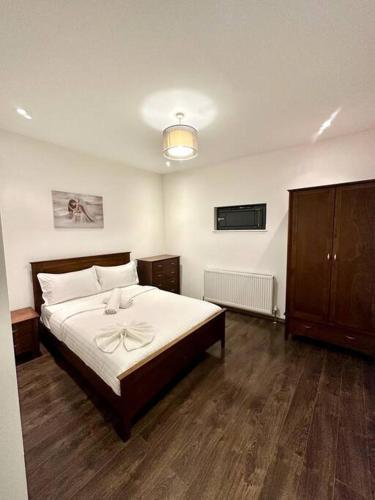 a bedroom with a bed with a bow on it at Alarabi Apartments-Peckham in London