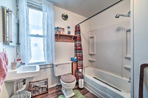 a bathroom with a toilet and a sink and a tub at Historic Houghton Lake Getaway Near Shoreline in Houghton Lake
