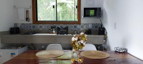 a kitchen with a table with two plates and a sink at Chalé Au Clair de Lune Terê in Teresópolis