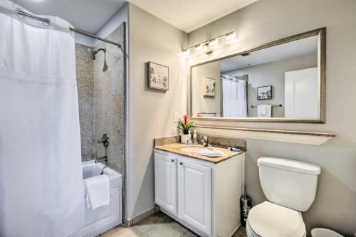 a bathroom with a toilet and a sink and a mirror at Family Resort Condo with 2 Pools 1 Mi to Disney! in Orlando