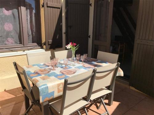 une table avec des verres et un vase de fleurs sur elle dans l'établissement Appartement T2 Mezzanine, 6 couchages, bord de plage, parking privé, proche commerces et Aqualand - FR-1-81-47, à Port-Leucate
