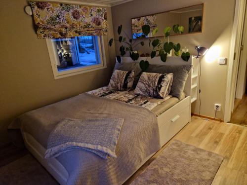 a small bedroom with a bed and a window at Huumoriharju in Karkkila
