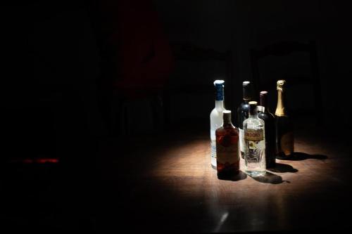 tres botellas de vino sentadas en una mesa en la oscuridad en LaBebe - Vidraru, en Arefu