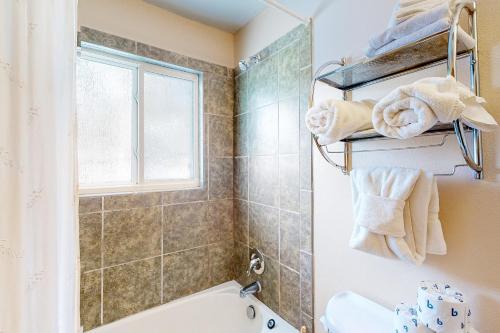 a bathroom with a tub and a shower and a window at The Sanctuary Bldg 5 #7-8 in Winter Park